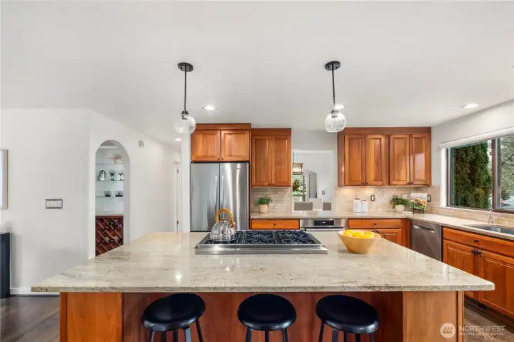 Spacious kitchen featuring a large island with seating, abundant storage, and a convenient pass-through to the dining room, ideal for effortless entertaining.