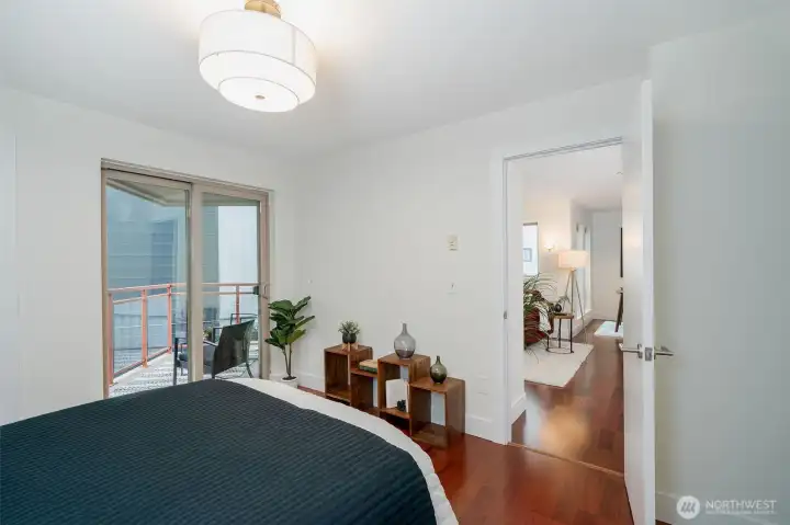 The primary bedroom offers room to breathe with space for a queen bed, nightstands, and storage furniture. Step out to your private balcony for a peaceful morning routine above the city.