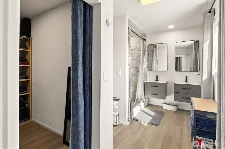 Primary bathroom with walk in closet, large shower, two sinks and water closet.
