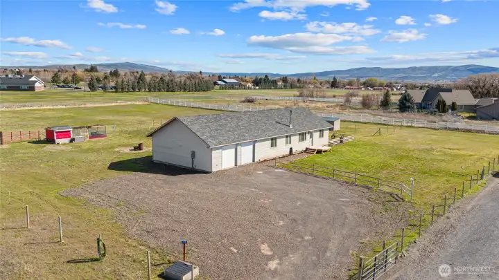 Aerial of front of home with driveway and large parking pad.