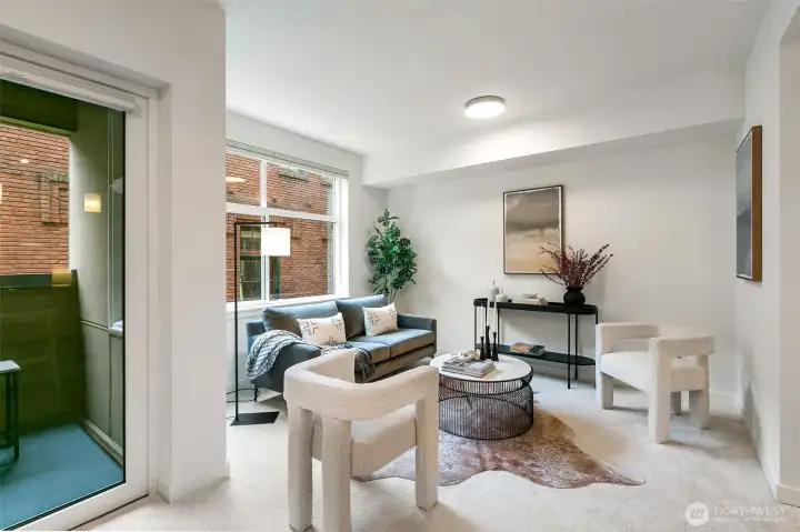 Open-concept living meets everyday comfort with expansive windows, flexible blinds, and an A/C port ready for summer.