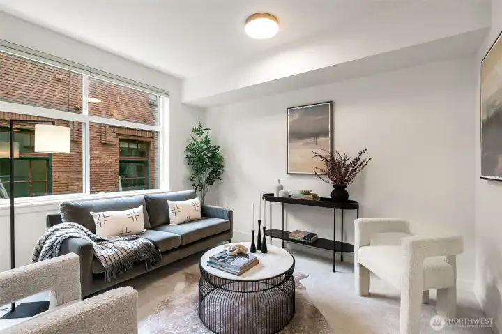 The light-filled living room features oversized windows, dual-action blinds, an open layout, and an A/C port for year-round comfort.