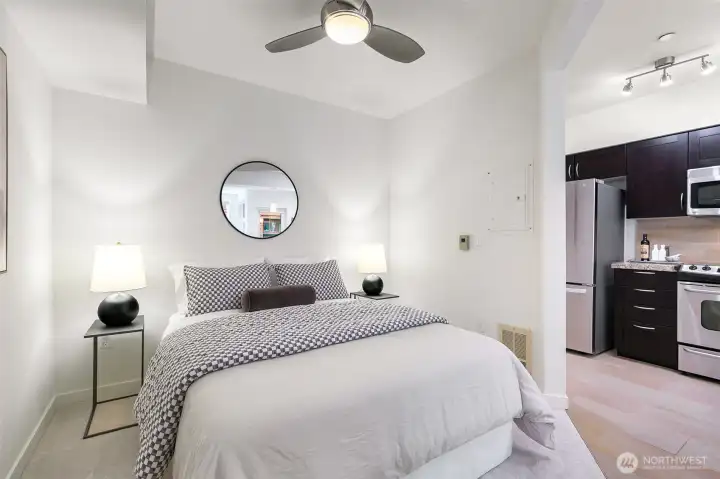 The cozy alcove bedroom features a ceiling fan for year-round comfort.