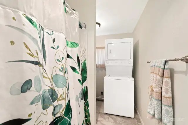 Shower/tub on left and washer and dryer are conveniently located in this area.