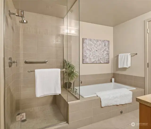 Views of the tile walk-in shower with rain shower head, adjacent to the sizeable soaking tub.