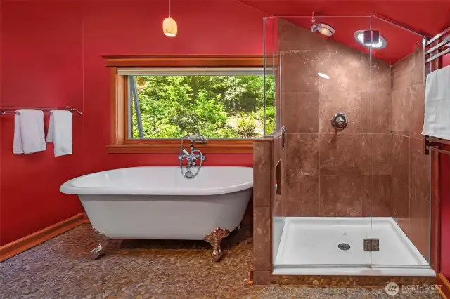 Romantic claw foot tub, adjacent to a lovely glass encased shower.