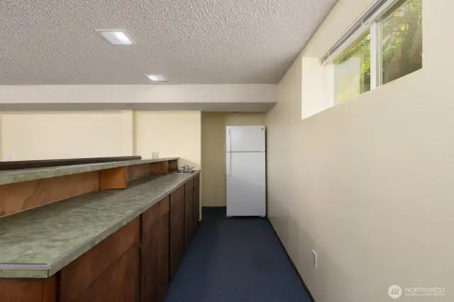 Basement bar area includes refrigerator and sink