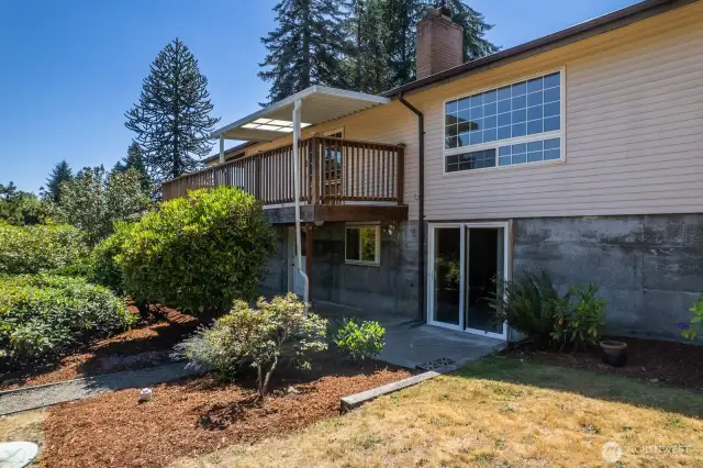 Back of home, showing sliding glass door entry into basement. There is also another entry to the basement (not visible here) to the left of the slider