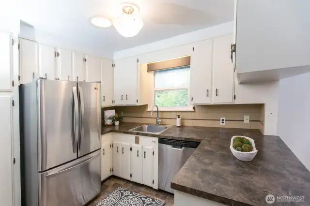 Kitchen lives larger than its footprint with ample countertop workspace, pass through to dining room and views of beautiful back yard. Solatube keeps it light and bright. All appliances are included.