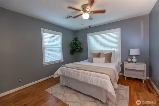 Primary bedroom - original hardwoods, windows on 2 walls allow wonderful natural light.