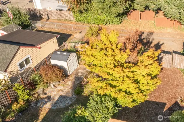 Aerial view of yard shed and another of the multiple patios, offering a quiet space to visit or just take in the fresh air and gorgeous gardens.