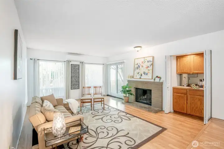 Living room features a cozy fireplace, wet bar, and large windows!