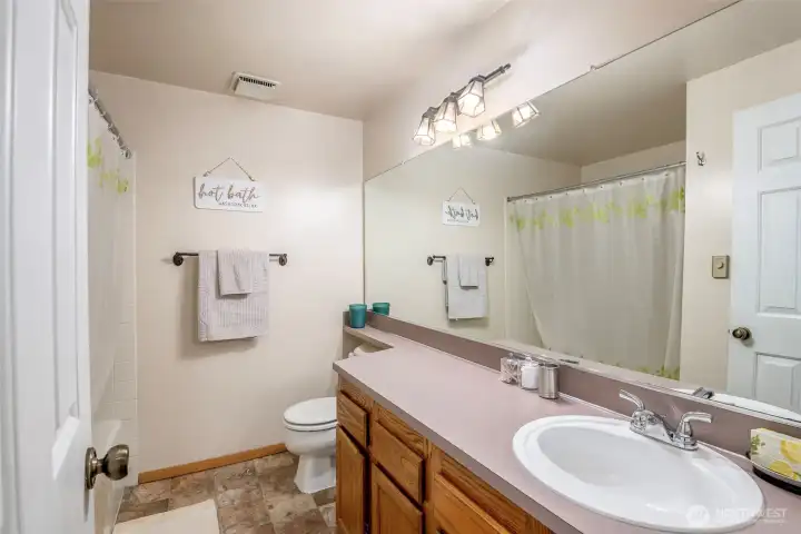 Hallway bathroom boasts a garden tub.