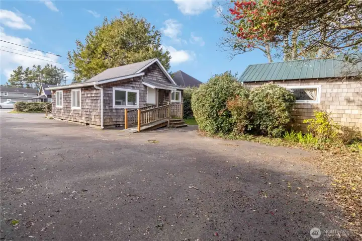 Low-maintenance yard is fully paved and hedged for privacy