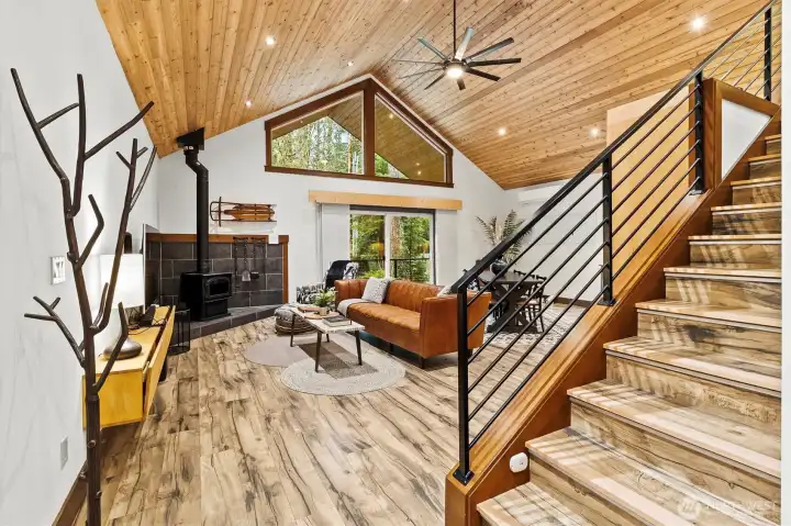 Living room with vaulted ceilings and wood stove.