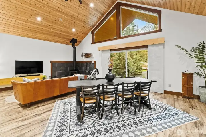 Open living and dining area with vaulted ceilings and large windows.
