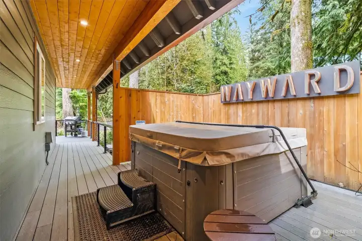 Private hot tub area with fenced enclosure for added privacy.