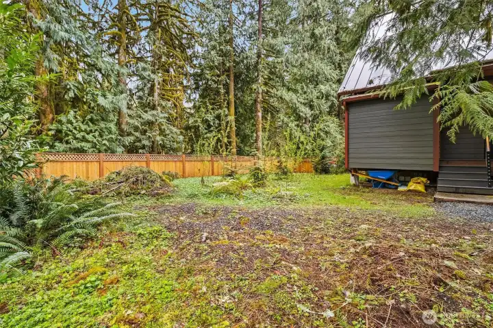 Level backyard space surrounded by mature trees.
