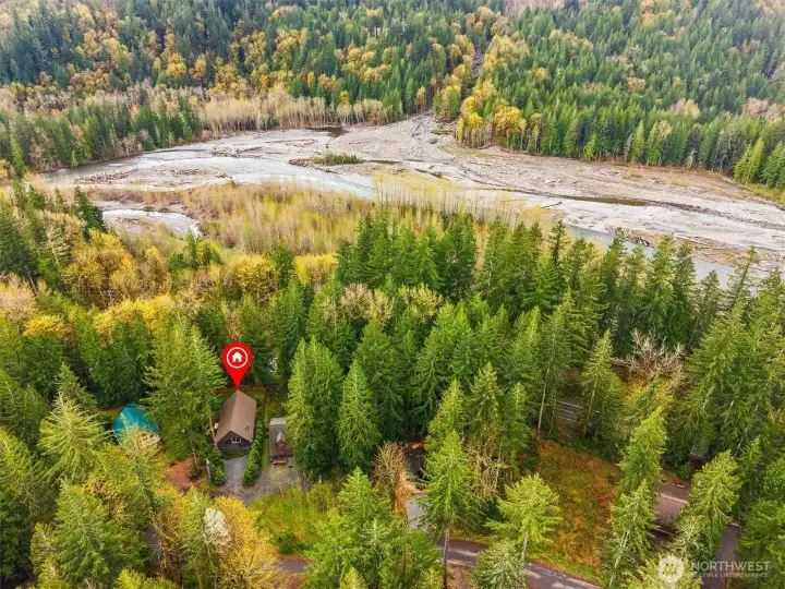 Scenic surroundings with forest, river, and mountain backdrop.