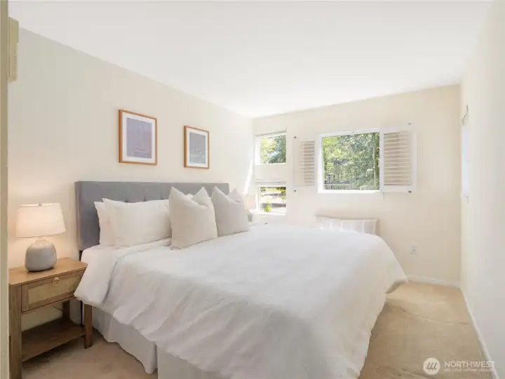 Wake up to soft natural light and views of surrounding greenery in this peaceful bedroom retreat.