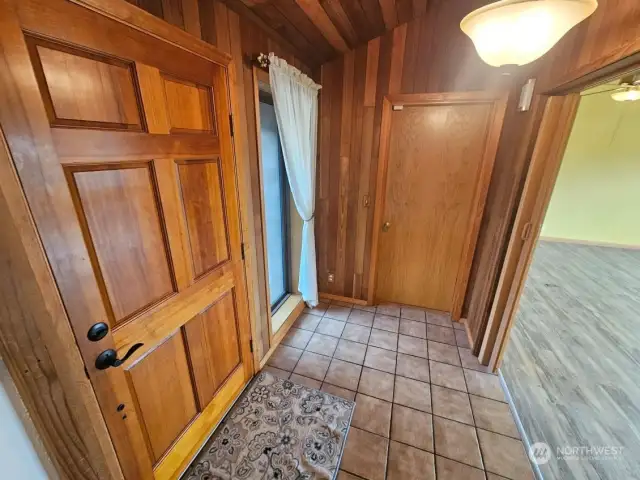 Entry with beautiful woodwork and tile.