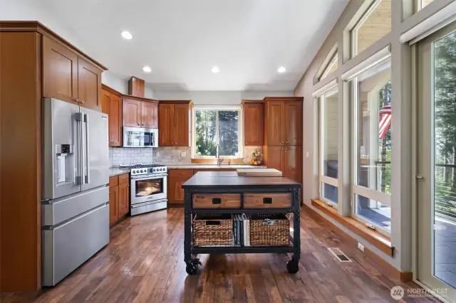 Spacious kitchen with stainless-steel appliances, gas burner stove, refrigerator, built-in microwave.