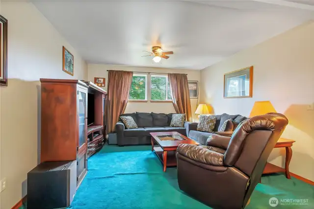 The downstairs recreation space is perfect for movie nights, game days, or casual gatherings, with a slider that opens to the backyard for easy indoor-outdoor flow.