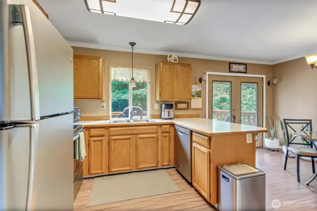 Convenient kitchen with eating bar, stylish appliances, pantry, and bright window—open to dining room for easy entertaining.