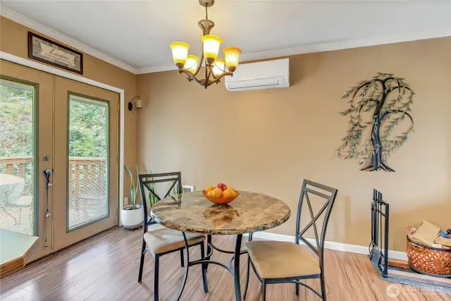 The dining area just off the kitchen features a mini-split system for year-round comfort and French doors that open to the outdoor deck, creating a seamless flow for indoor-outdoor entertaining.