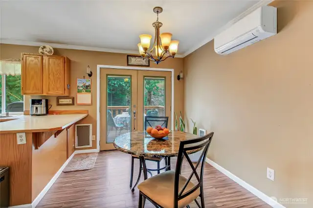 Dining area situated between the kitchen and living room, featuring French doors that open to the outdoor deck—perfect for easy indoor-outdoor entertaining.