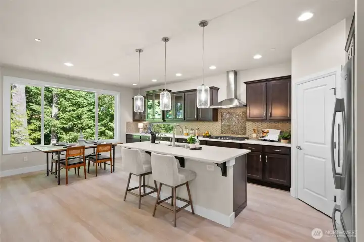 The open concept design blends the kitchen, island seating and dining room into one inviting space.
