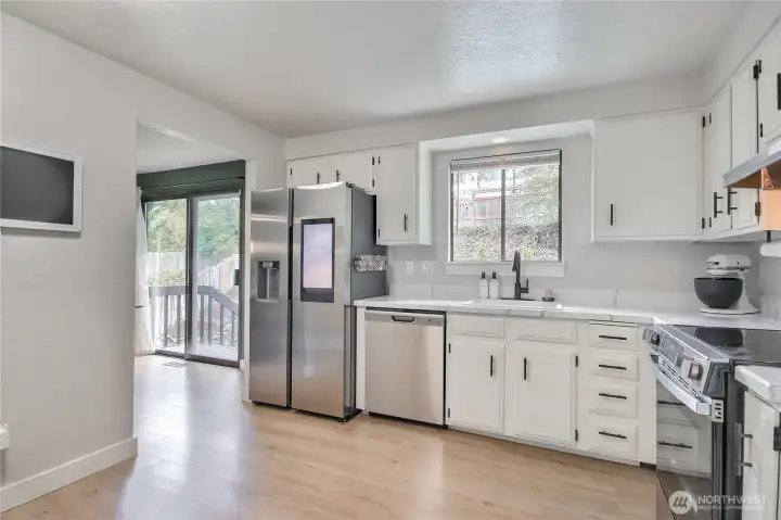 Kitchen features brand-new stainless appliances and hardware with tons of cabinet and counter space.