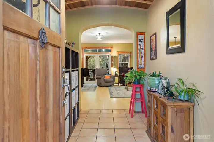 Entry features tile flooring, a stunning wood ceiling, and charming rounded archways