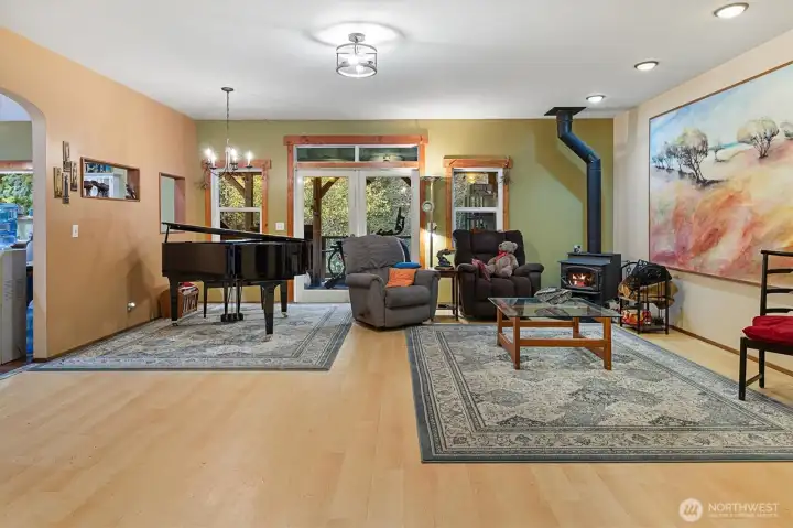 Spacious living area with a wood-burning stove and French doors leading to the covered back deck