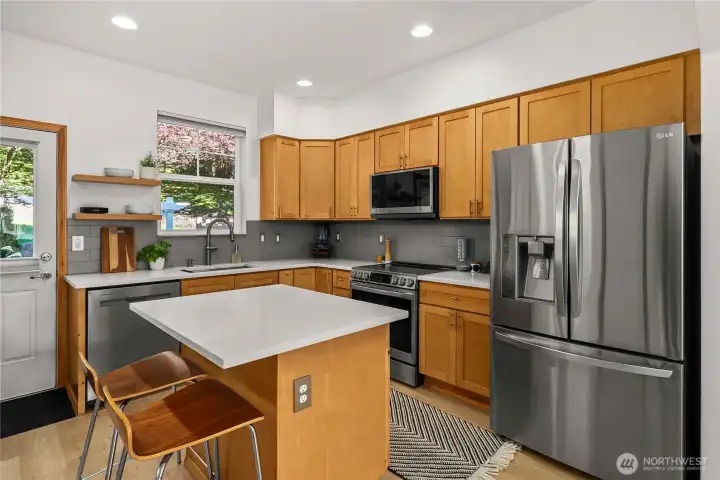 Stainless steel appliances and contemporary tile backsplash