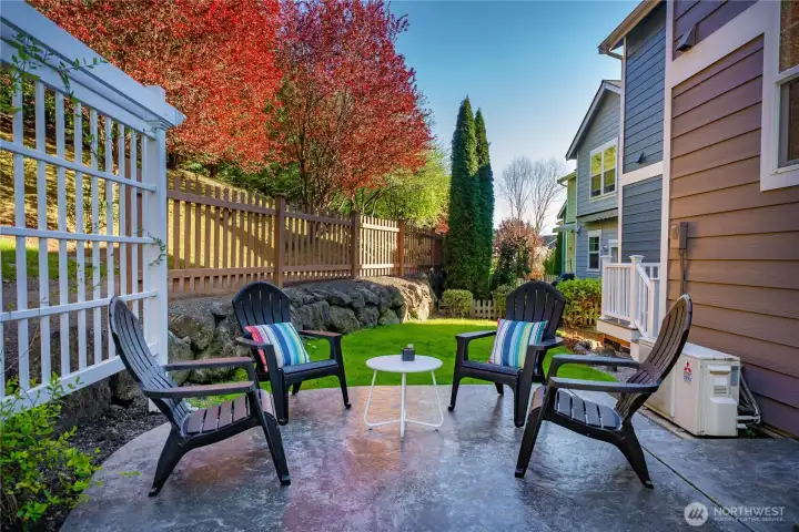 Private feeling patio retreat—perfect for relaxing or gathering—framed by lush greenery