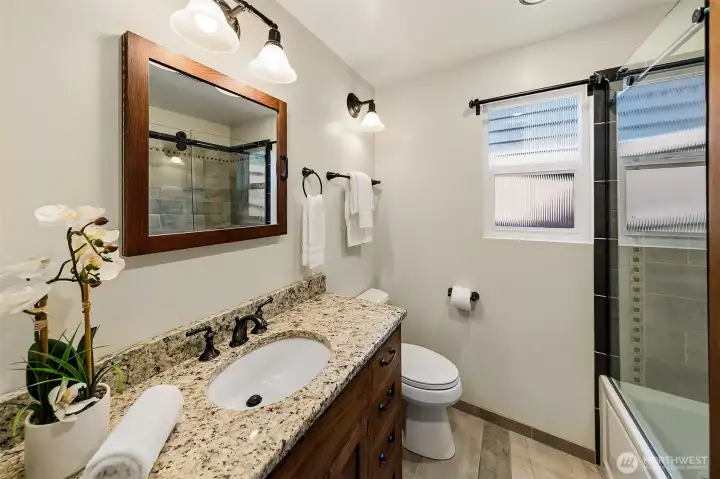 Main floor hall bathroom has heated circulating tub & tile enclosure.