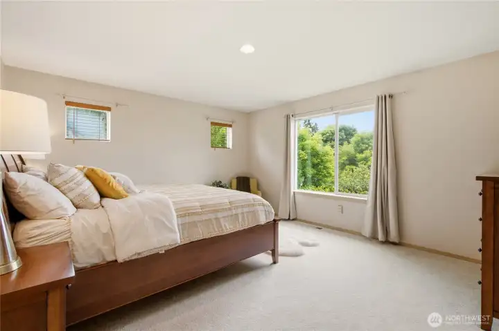 Large primary bedroom with peaceful ambiance & views of the Cascade Mountain Range Large primary bedroom with peaceful ambiance & views of the Cascade Mountain Range