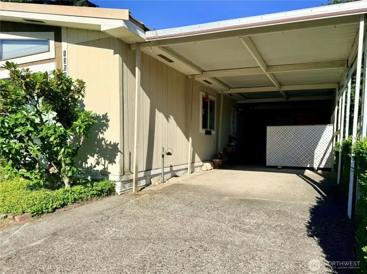 Carport, with a storage building in the back.