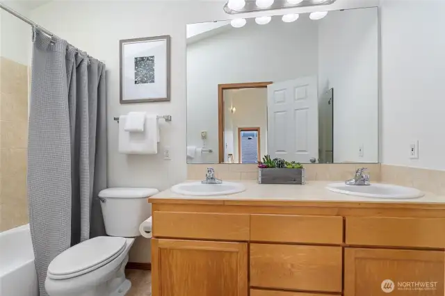The top floor full bath with double sinks has vaulted ceilings and a skylight.
