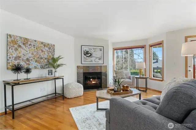 The cozy living room has beautiful morning sunlight that streams through the front windows.