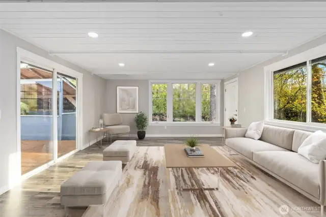 Step into the elegant living room, where sophisticated wood ceilings exude glamour and create a fantastic retreat for gaming or watching TV. This room is bathed in natural light streaming through abundant wood-wrapped windows, fostering a comfortable and inviting atmosphere. It also features a glass door leading to the backyard deck, and another door to the other side of the yard, allowing you to extend your entertainment outdoors perfect for hosting gatherings! Entertain in style in this cozy space, complemented by a wonderful floor plan designed for both comfort and enjoyment.