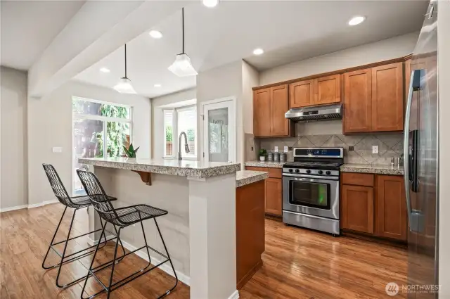 Open concept kitchen with breakfast bar and pendant lighting