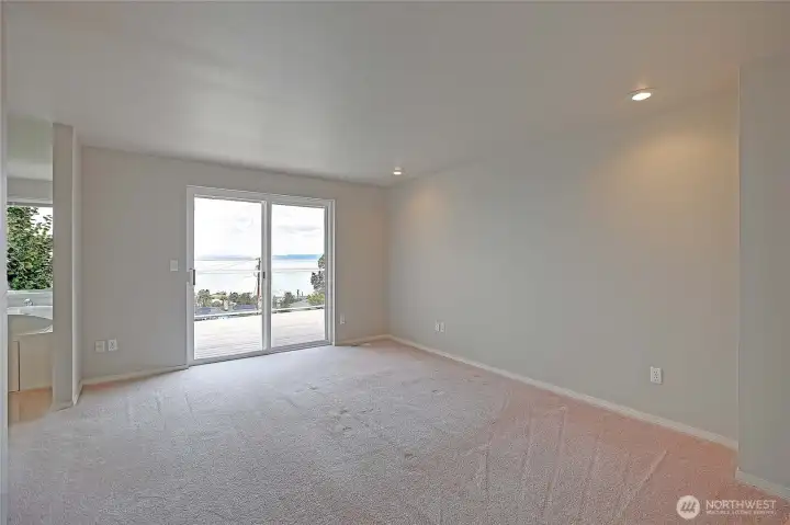 Primary bedroom with sliding doors to the deck to enjoy the view of the water and mountains