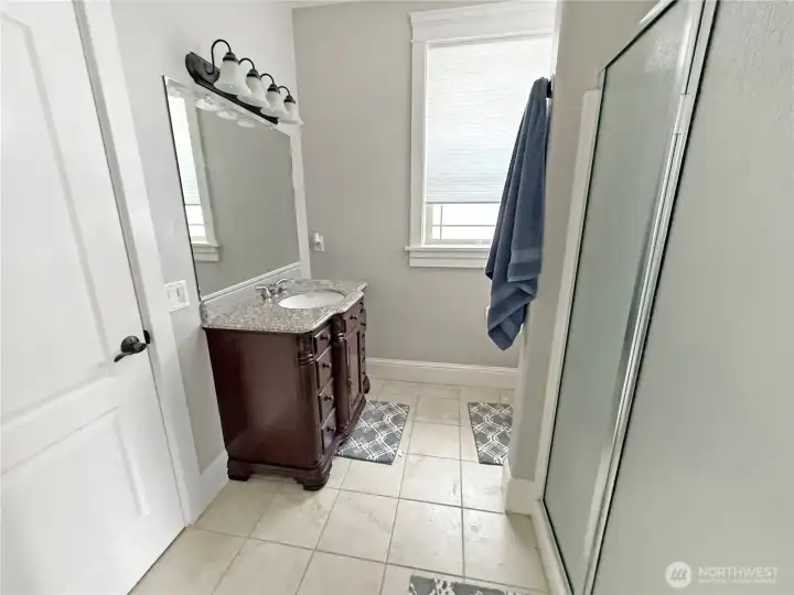 The 3/4 bath with tile floor offers access from both guest bedrooms.
