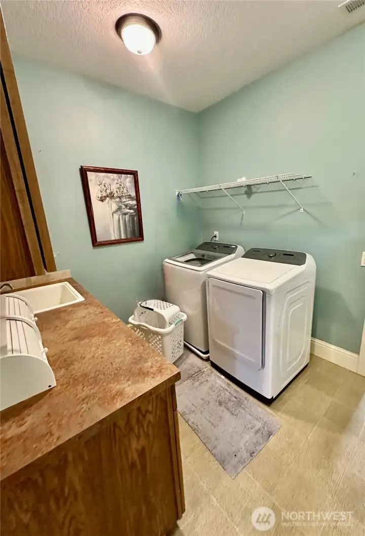 Utility room with cabinet space, laundry sink and access to the hobby/craft room.