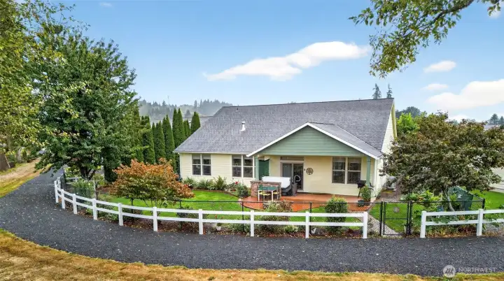 Rear view of the home that shows the fenced yard and walking trail.
