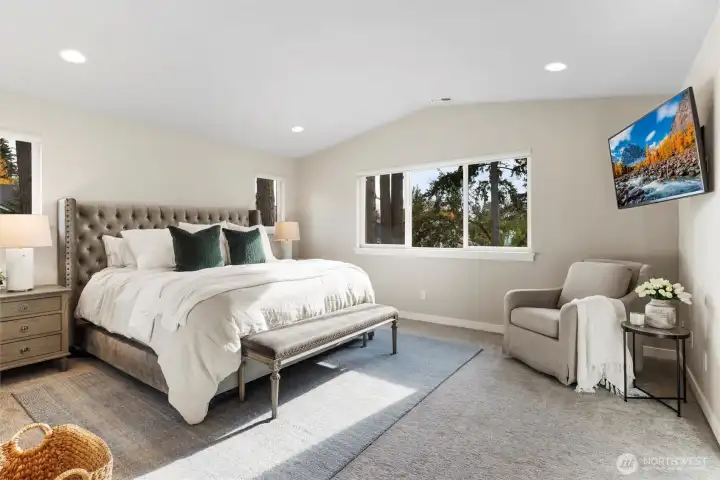 Primary Bedroom with spa inspired ensuite bath and vaulted ceilings. Remote operated blinds and custom mounted TV.