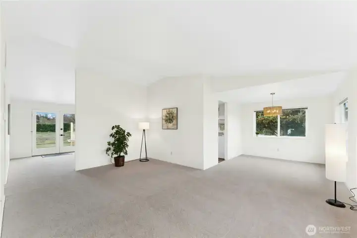 Step inside to a welcoming living area, with the dining space to the right and views of the expansive backyard through the French doors.