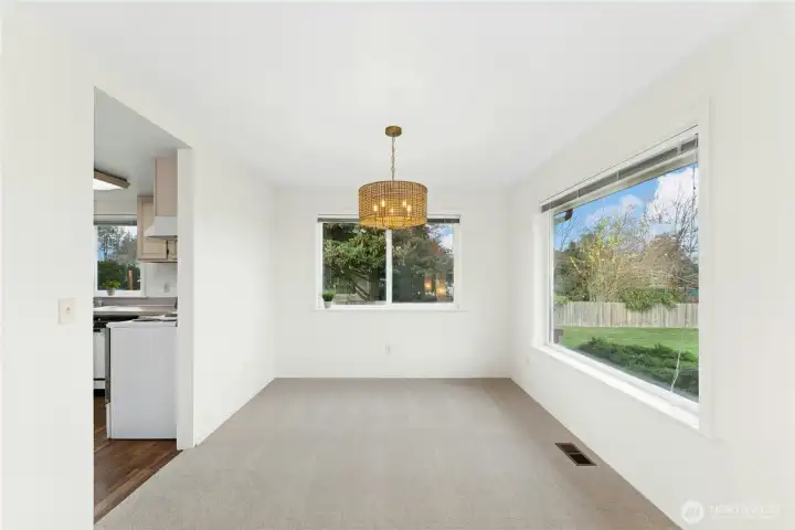 Bright, perfectly appointed dining area featuring natural light and a stylish updated light fixture.